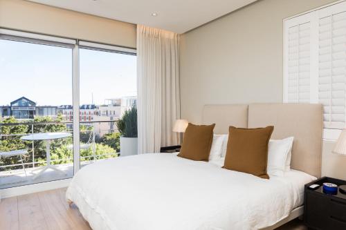 a bedroom with a white bed and a large window at 401 Dovenby in Cape Town