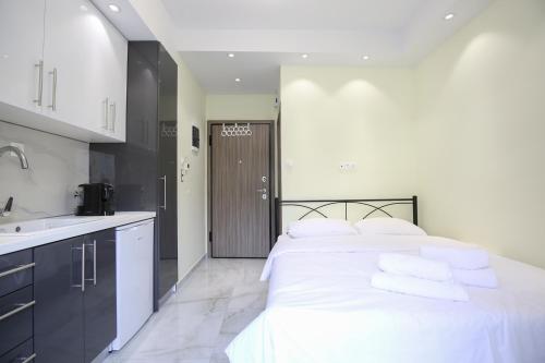 a bedroom with a bed with white sheets and a sink at #7 Ioanna Apartments in Thessaloniki