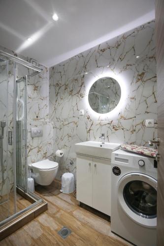 a bathroom with a toilet sink and a washing machine at #7 Ioanna Apartments in Thessaloniki