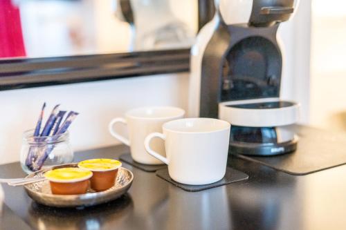 a counter with two cups and a coffee maker at Urban Retreat Apartment - Whirpool - Top Lage in Cologne