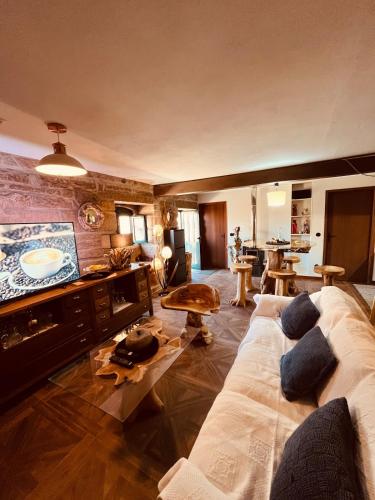 a living room with a couch and a tv at Casa da Renda in Campos