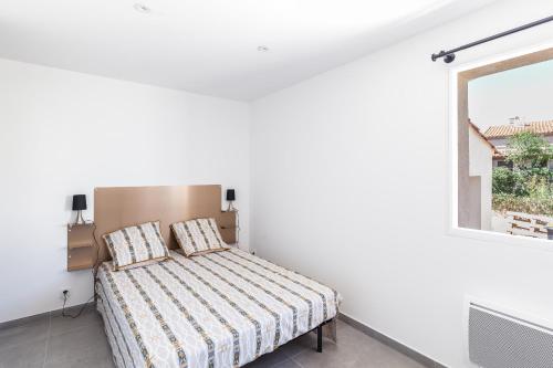 un lit dans une chambre blanche avec une fenêtre dans l'établissement 