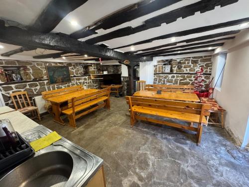 a kitchen with wooden benches and a stone wall at Guest house Elenite in Elena
