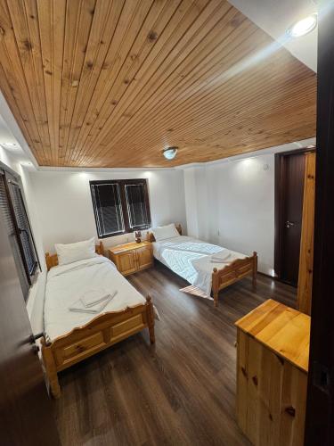 a bedroom with two beds and a wooden ceiling at Guest house Elenite in Elena