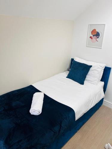 a white bed with blue and white pillows in a room at Waterside Stay- 3 Bed House- Sleeps 5- Parking- Fast Wifi in Burton upon Trent