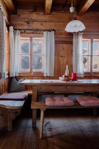 a dining room with a table and benches in a cabin at ZIRBENHütte in Abtenau