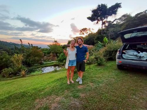a man and a woman standing next to a car at Aloha chirripo cabaña familiar in Convento