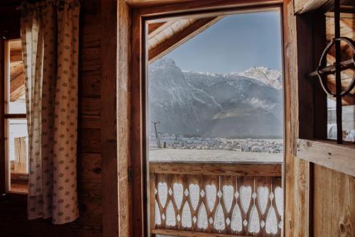 a window in a cabin with a view of a mountain at ZIRBENHütte in Abtenau