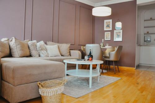 a living room with a couch and a table at PLAN Superior Apartment Niš, centar, FREE parking in Niš