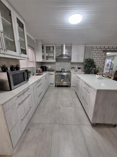 a large kitchen with white cabinets and a stove at Gezondheid in Velddrif