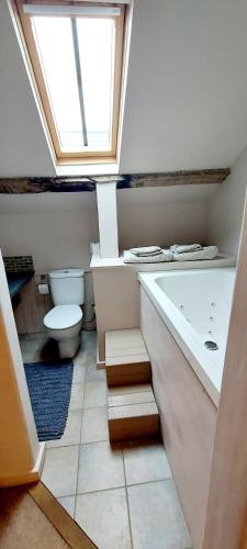a bathroom with a toilet and a tub and a sink at Priors Marston in Priors Marston