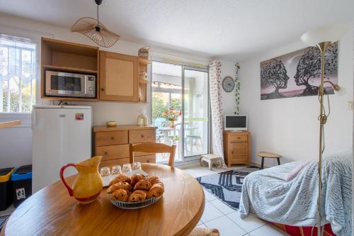 - une cuisine avec une table et un bol de pain dans l'établissement L'Esprit Bohème - Terrasse - Proche camp naturiste, au Cap d'Agde