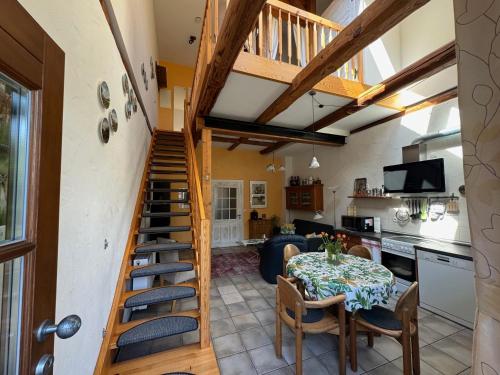 ein Wohnzimmer mit einer Treppe, einem Tisch und einer Küche in der Unterkunft Gästehaus Peerhus Dönsel - jung lüüd in Rehden