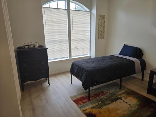 a bedroom with a bed and a dresser and a window at Fresh Crash Pads 4 in Houston