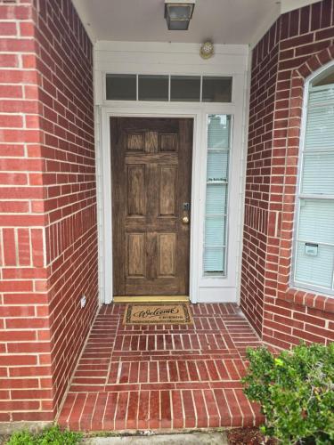 a brick house with a door with a welcome mat in front at Fresh Crash Pads 4 in Houston