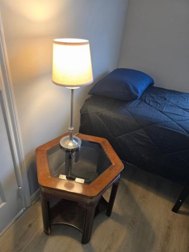 a lamp on a table next to a bed at Fresh Crash Pads 4 in Houston