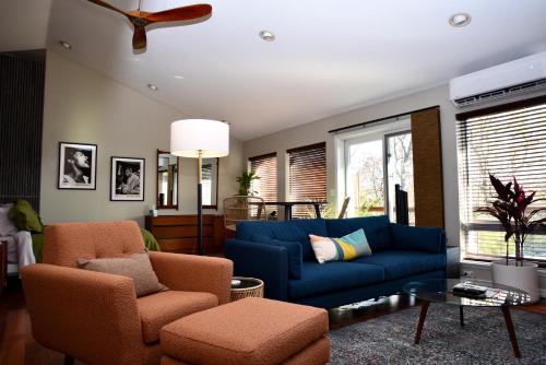 a living room with a blue couch and two chairs at Beaver Lake Cottages in Eureka Springs