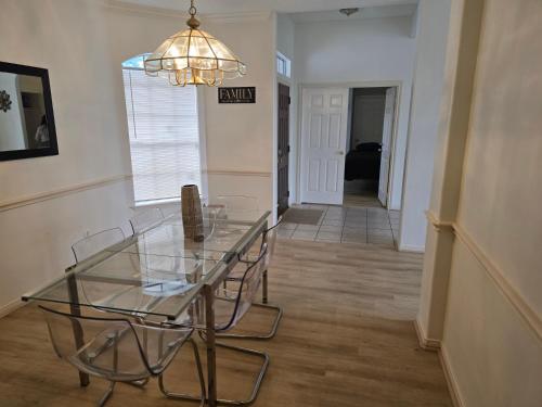 a dining room with a glass table and a chandelier at Fresh Crash Pads 4 in Houston