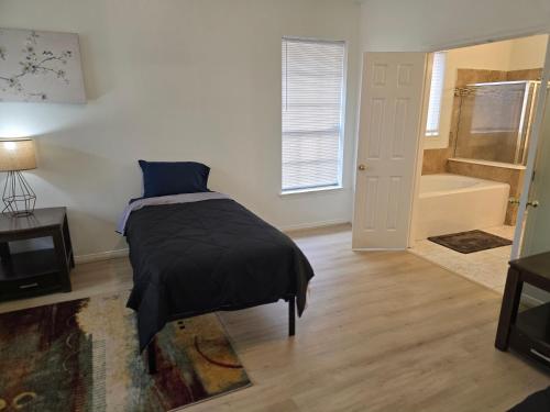 a bedroom with a bed and a tub in a room at Fresh Crash Pads 4 in Houston