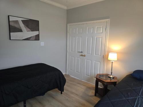 a bedroom with a bed and a table with a lamp at Fresh Crash Pads 4 in Houston