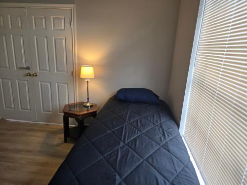 a bedroom with a bed and a lamp next to a door at Fresh Crash Pads 4 in Houston