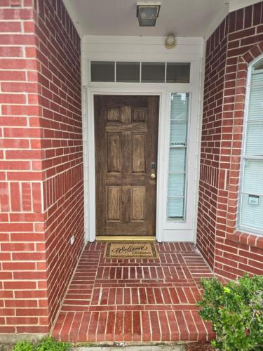 a brick house with a door with a welcome sign on it at Fresh Crash Pads 4 in Houston