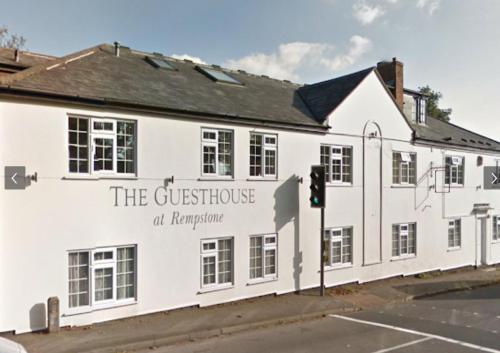 a white building with a sign on the side of it at Apple Blossom Guesthouse in Rempstone