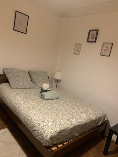 a bedroom with a bed with a lamp and pictures on the wall at Laurence in Paris