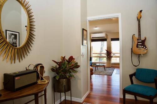 a living room with a mirror and a guitar on the wall at Beaver Lake Cottages in Eureka Springs