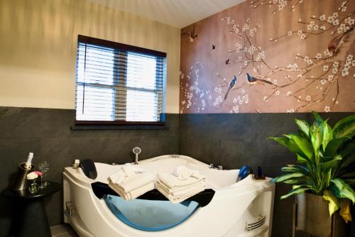 a bathroom with a tub with towels and a window at Beaver Lake Cottages in Eureka Springs