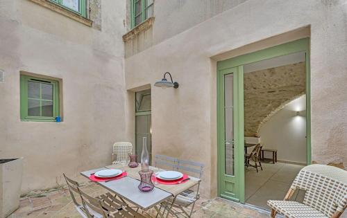 d'une terrasse avec une table, des chaises et une porte. dans l'établissement L 'Écrin de Pierre, à Nîmes