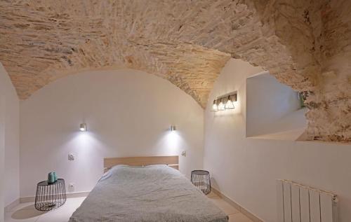 une chambre avec un lit et un mur en pierre dans l'établissement L 'Écrin de Pierre, à Nîmes
