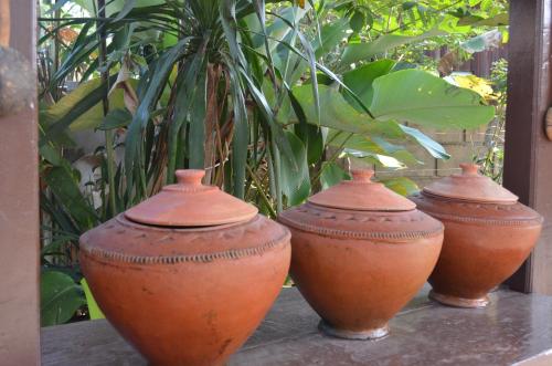 four clay vases sitting on a table with plants at Baan Aew Pai in Pai