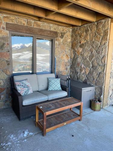 a couch and a coffee table in front of a stone wall at Newly Renovated Ski In Ski Out 2BR Condo in Crested Butte
