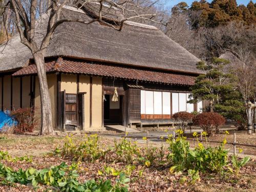 a building with a tree and flowers in front of it at Taira View Hotel in Iwaki