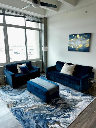 a living room with two blue couches and a rug at Piedmont Perch in Atlanta