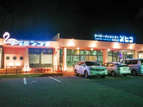 two cars parked in a parking lot in front of a store at Taira View Hotel in Iwaki