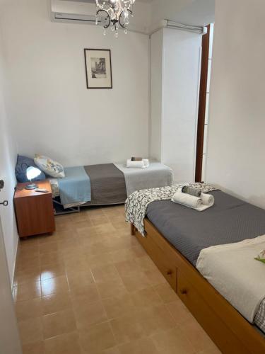 a room with two beds and a chandelier at Sweet Home Sofia in Norma