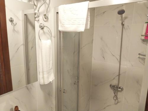 a bathroom with a shower with a glass door at Akraios Guesthouse Beautiful Stone House in Konak in Konak