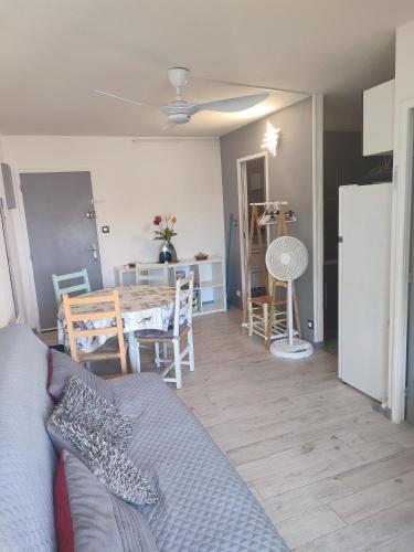 - un salon avec un canapé et une table à manger dans l'établissement Appartement T2 en bord de mer - Les Capounades, à Narbonne-Plage
