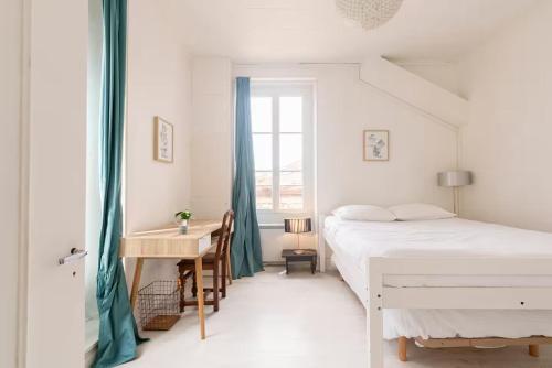 une chambre avec un lit, un bureau et une fenêtre dans l'établissement Appartement 4 personnes - Cité de la gastronomie, à Dijon