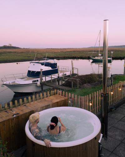 two people in a bath tub at a dock at Hot Tub With A View - Christchurch Harbour in Christchurch