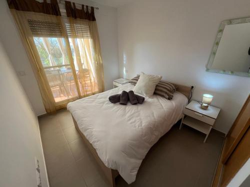a bedroom with a white bed with a window at Villa Eric in Roldán