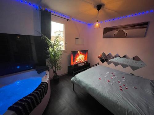 a bedroom with a tub and a bed and a tv at Love room Buenas noches SPA et bord de mer in La Seyne-sur-Mer