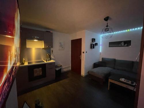 a living room with a couch and a kitchen at Love room Buenas noches SPA et bord de mer in La Seyne-sur-Mer