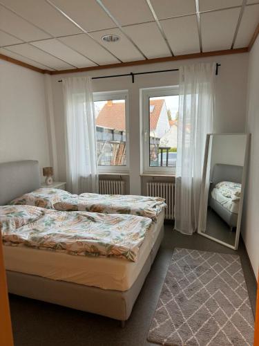 a bedroom with two beds and two windows at Ferienhaus Alte Bank in Göcklingen in Göcklingen