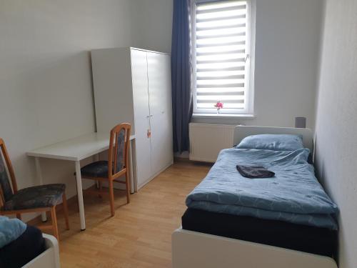 a bedroom with a bed and a desk and a table at Monteurwohnung bei Nina 2OGR in Zeitz
