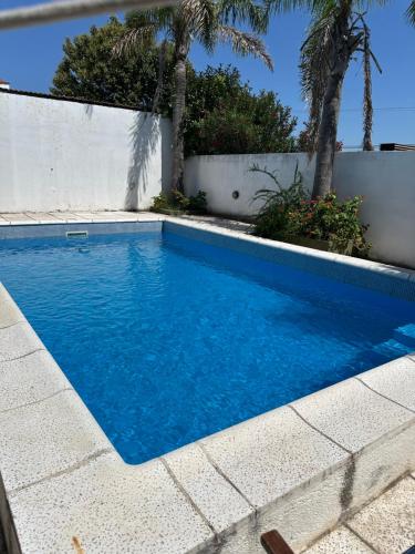 een zwembad met blauw water en palmbomen bij Casa en Villa Carlos Paz in Villa Carlos Paz