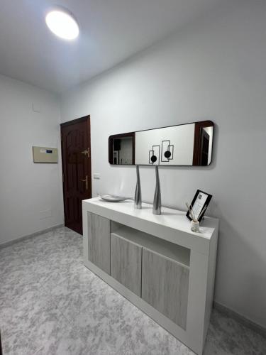 Una habitación con un tocador con un espejo en la pared. en Apartamento RUAL, en Sanxenxo