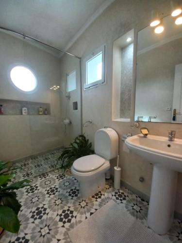 une salle de bain avec toilettes, lavabo et miroir dans l'établissement Lumière de Tanger, à Tanger